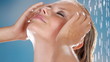 Close up of a beautiful young woman wetting her hair in a shower