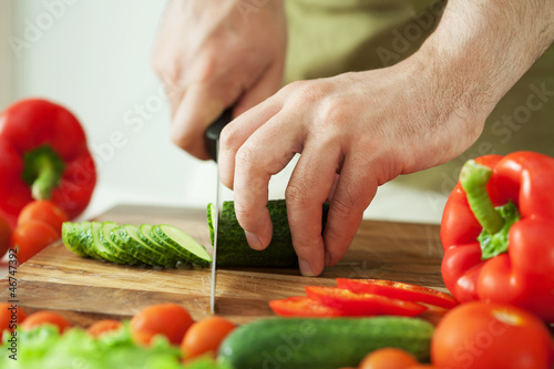 Photo: man cutting vegetables for salad man cutting vegetables for salad