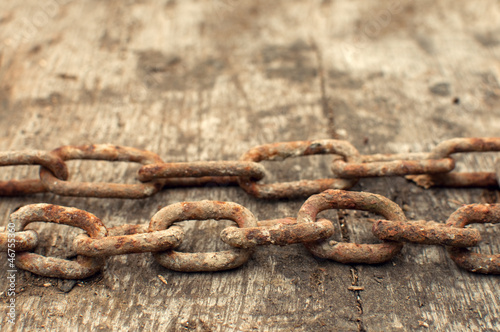 Photo: Rusty chain and weathered wood background Rusty chain and weathered wood background