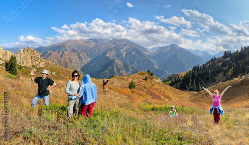 Photo: Funny group of people hiking on the meadow of mountain Funny group of people hiking on the meadow of mountain
