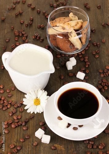 Photo: A cup of strong coffee and sweet cream on wooden table close-up A cup of strong coffee and sweet cream on wooden table close-up