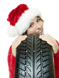 Miss santa leans against a tire waiting for christmas