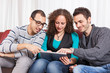 Three Friends with Tablet PC on a Sofa