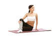 Young woman practising yoga on mat isolated