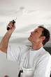 Man painting ceiling white