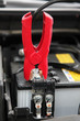 Jumper Cable connected to automobile car battery.