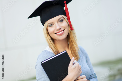Photo: Female graduate holding book Female graduate holding book