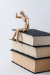 Eine Zeichenpuppe sitzt auf einem Stapel Bücher