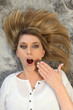 Sleepy woman lying on a rug with her hair spread