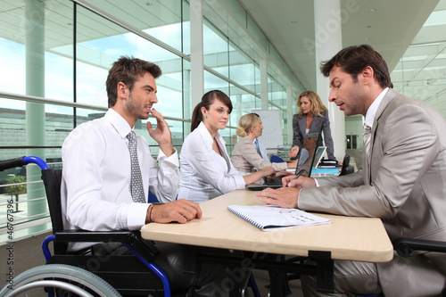 Photo: Man in wheelchair working in an office Man in wheelchair working in an office