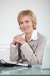 Woman sitting at her desk with laptop and open diary