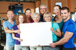 Gruppe hält leeres Schild im Fitnesscenter