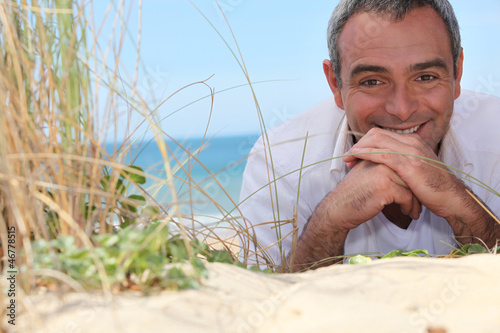 Photo: mature man resting at the beach mature man resting at the beach