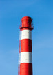 Foto: Red and white factory chimney against blue sky Red and white factory chimney against blue sky