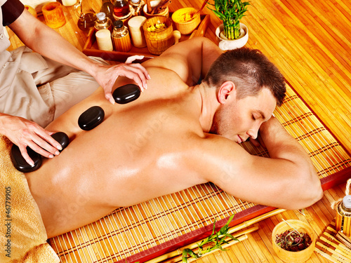 Photo: Man getting stone therapy massage . Man getting stone therapy massage .