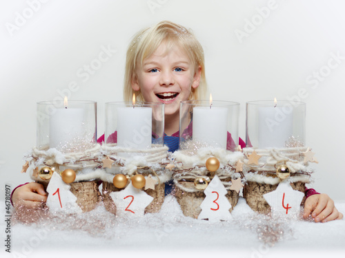 Photo: Cute blond child with Advent wreath waiting for christmas Cute blond child with Advent wreath waiting for christmas