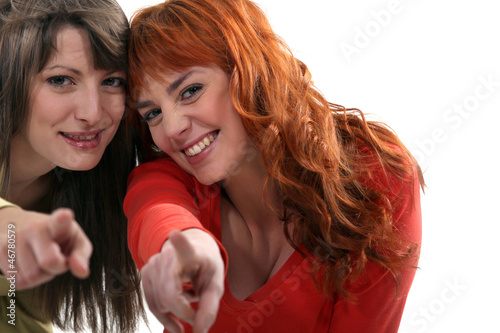 Photo: Two friends pointing at the camera. Two friends pointing at the camera.