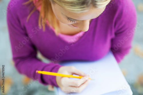Photo: Female student writing in notebook Female student writing in notebook