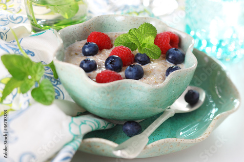 Photo: Oatmeal with fresh berries in ceramic dish. Oatmeal with fresh berries in ceramic dish.