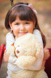 Small beautiful girl and amusing bear
