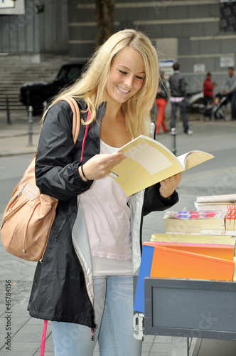 Photo: Junge Frau vor Bücherladen Junge Frau vor Bücherladen