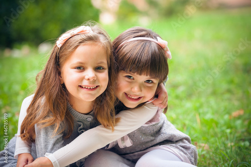 Photo: Happy little girlfriends in park Happy little girlfriends in park