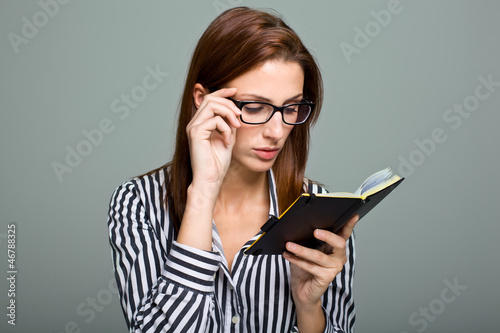 Photo: Smart Serious Woman Reading a Diary Smart Serious Woman Reading a Diary
