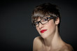 Photo: Young woman with glasses in front of a grey background Young woman with glasses in front of a grey background