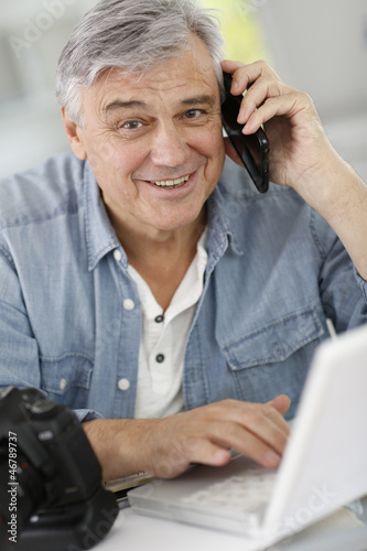 Photo: Photographer in office talking to client on the phone Photographer in office talking to client on the phone