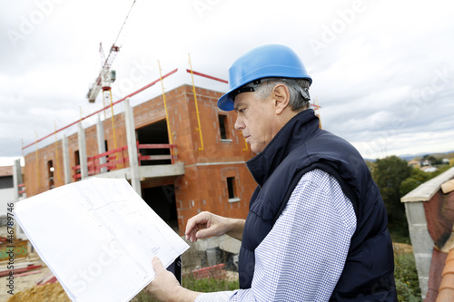 Photo: Construction manager checking building project on site Construction manager checking building project on site