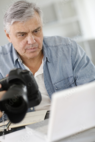 Photo: Senior reporter working in office in front of laptop Senior reporter working in office in front of laptop