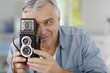 Senior photographer holding vintage camera