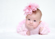 Portrait of a baby girl with a flower on her head on a white bac