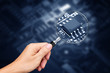 Hand holding magnifying glass with computer chip