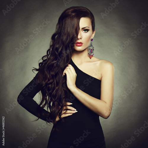 Photo: Portrait of beautiful brunette woman in black dress Portrait of beautiful brunette woman in black dress