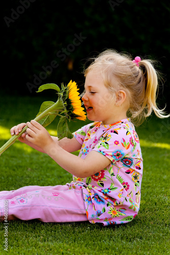 Photo: Kind mit Sonnenblume im Garten im Sommer Kind mit Sonnenblume im Garten im Sommer