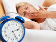 Schlaflos mit Uhr in der Nacht.