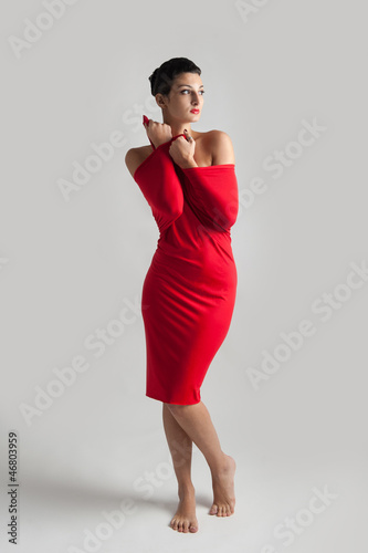 Photo: Beautiful brunette woman with red elastic cloth, studio shot. Beautiful brunette woman with red elastic cloth, studio shot.