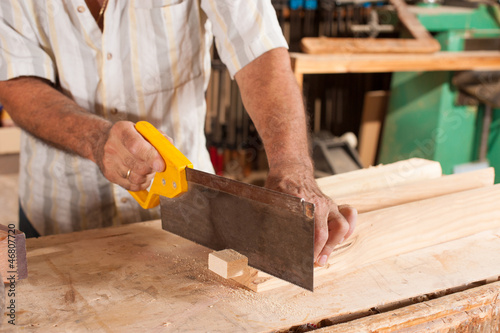 Photo: Carpenter with hand saw Carpenter with hand saw