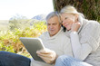 Senior couple using tablet in forest