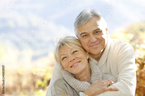 Photo: Senior couple embracing each other in countryside Senior couple embracing each other in countryside