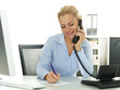 Pretty secretary makes notes while having a call at work