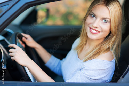 Photo: Smiling young woman sitting in car Smiling young woman sitting in car