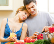 Photo: Cheerful young cooking couple at home Cheerful young cooking couple at home