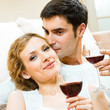 Cheerful couple with glasses of redwine