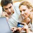 Cheerful couple paying by plastic card