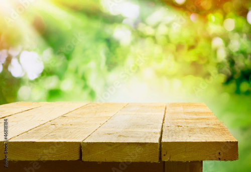 Photo: Empty wooden table with garden bokeh Empty wooden table with garden bokeh