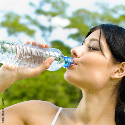 Photo: Portrait of woman drinking water outdoor Portrait of woman drinking water outdoor