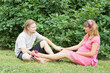 a happy young pregnant woman with her husband resting in a park