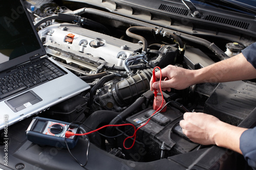 Photo: Car mechanic working in auto repair service. Car mechanic working in auto repair service.